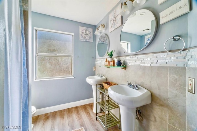 bathroom with toilet, hardwood / wood-style flooring, and dual sinks