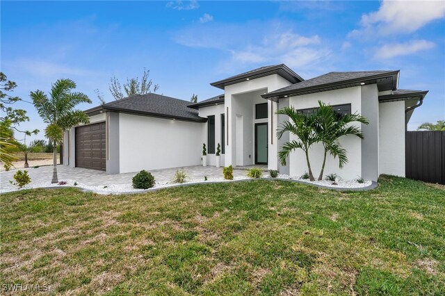 view of front of home with a front lawn and a garage