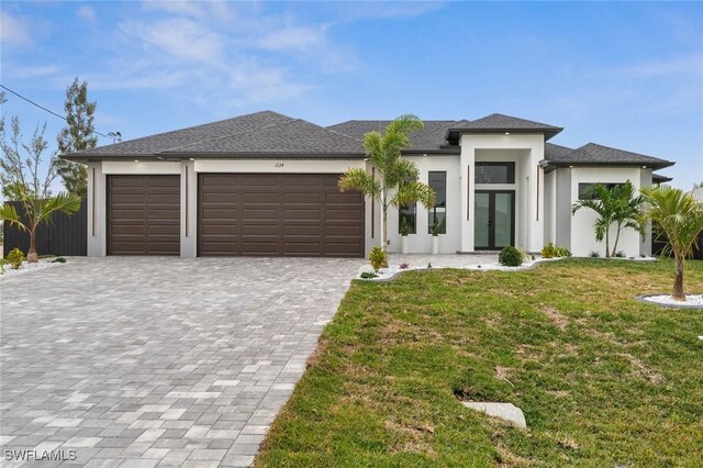 prairie-style home with a front lawn, a garage, and french doors