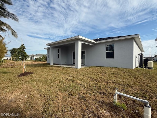 rear view of house featuring a patio and a lawn