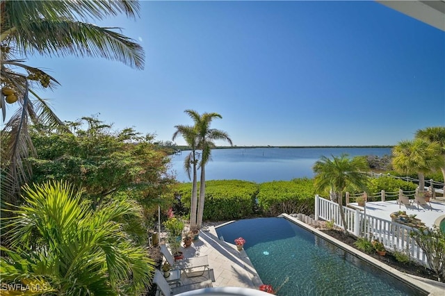 view of pool with a patio and a water view