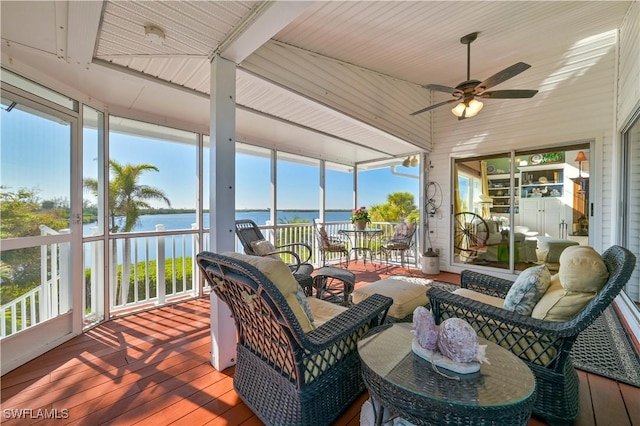 sunroom / solarium featuring a water view, ceiling fan, and a healthy amount of sunlight