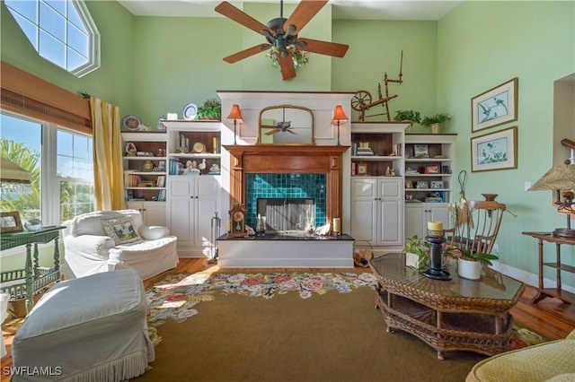 living area featuring ceiling fan, a fireplace, and hardwood / wood-style flooring