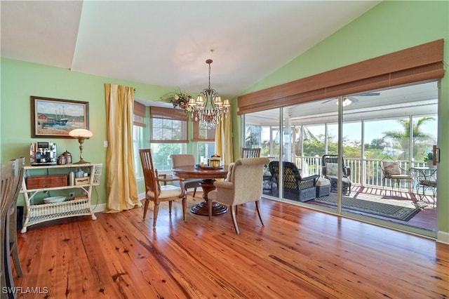 dining area featuring hardwood / wood-style floors, lofted ceiling, and a chandelier