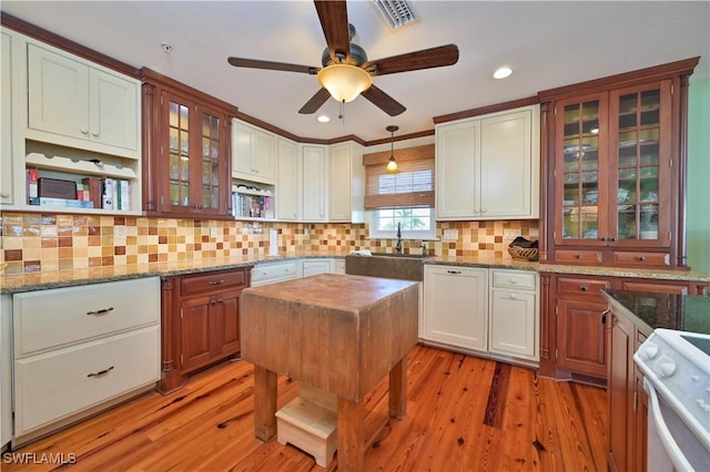 kitchen with ceiling fan, light wood-type flooring, white stove, and decorative light fixtures