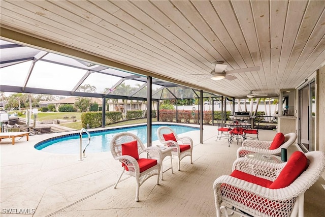 view of swimming pool featuring ceiling fan, a lanai, a grill, and a patio area