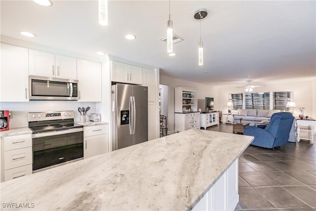 kitchen featuring stainless steel appliances, ceiling fan, pendant lighting, light stone counters, and white cabinets