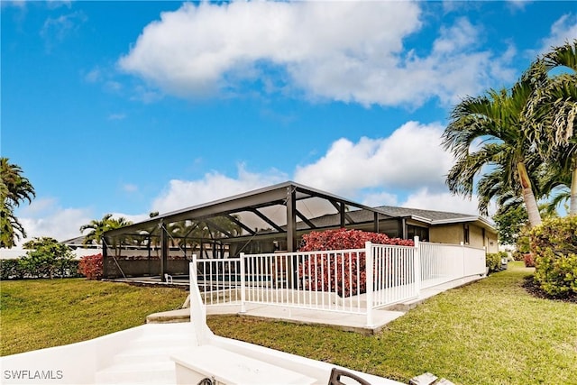 exterior space featuring a yard and glass enclosure