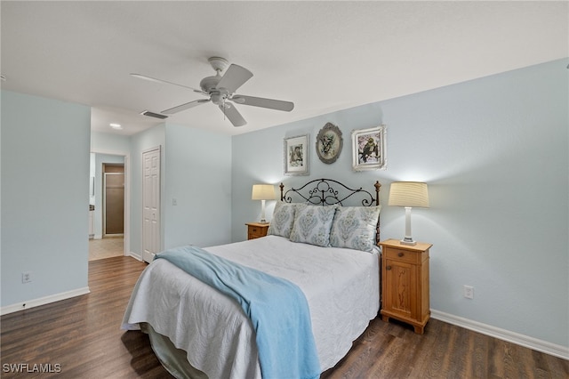 bedroom with dark wood-type flooring, ceiling fan, and a closet