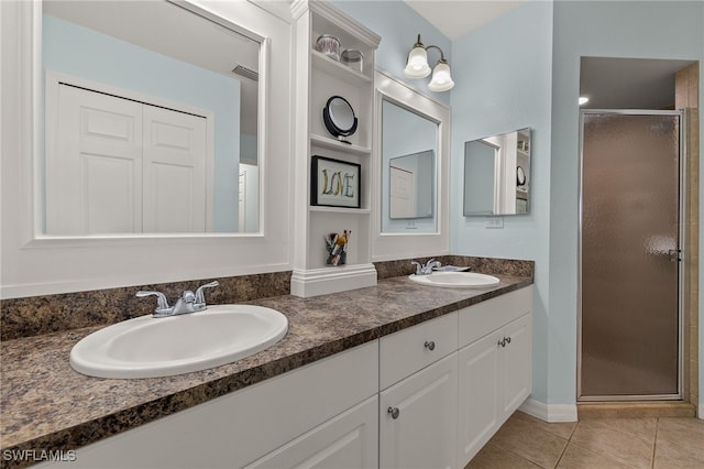 bathroom with vanity, tile patterned flooring, a shower with shower door, and built in shelves