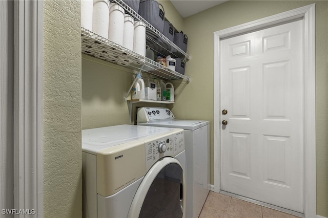 laundry area featuring light tile patterned flooring and washing machine and clothes dryer