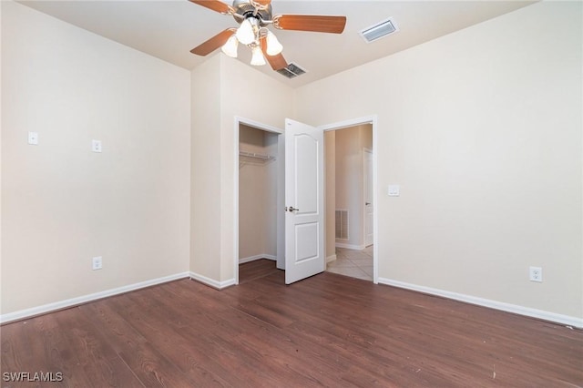 unfurnished bedroom with a closet, ceiling fan, and dark wood-type flooring