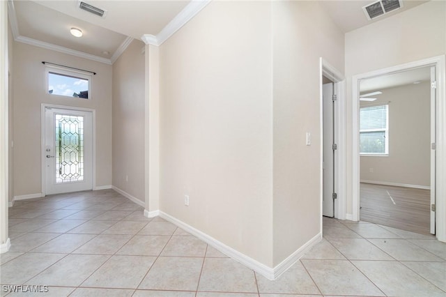 foyer entrance featuring light tile patterned floors and crown molding