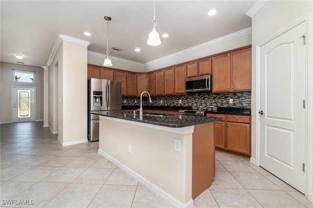 kitchen with appliances with stainless steel finishes, dark stone counters, a kitchen island with sink, sink, and light tile patterned flooring