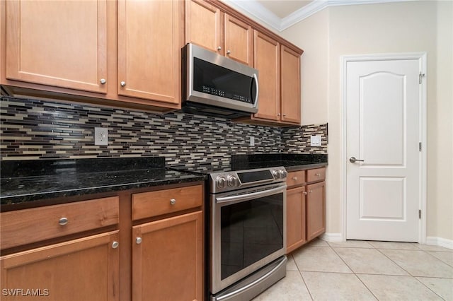 kitchen with decorative backsplash, dark stone countertops, light tile patterned floors, ornamental molding, and stainless steel appliances