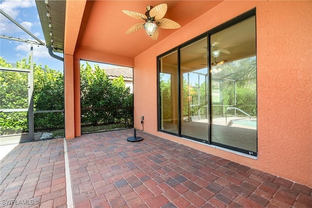 view of patio featuring glass enclosure and ceiling fan