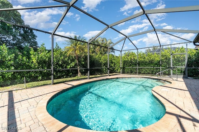 view of swimming pool with glass enclosure and a patio