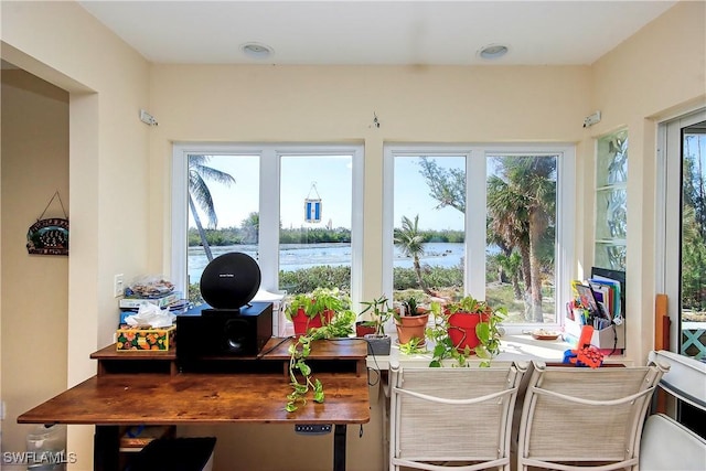 sunroom with plenty of natural light and a water view