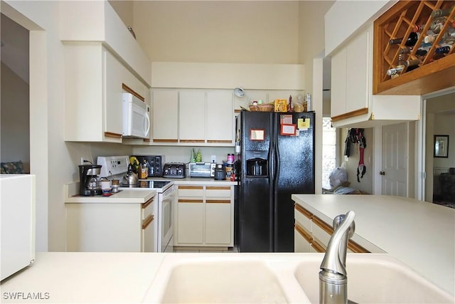 kitchen featuring sink, white appliances, and white cabinets