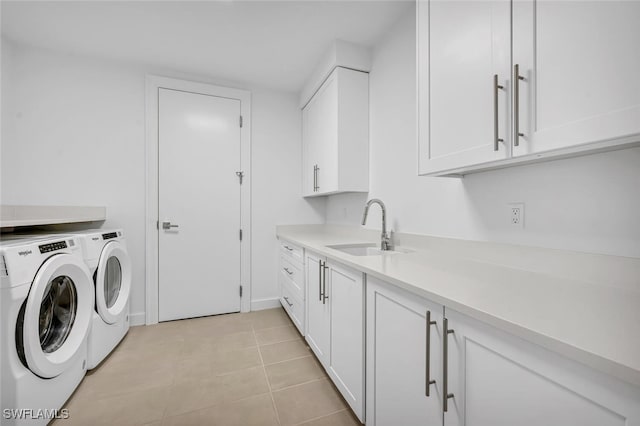 washroom with cabinets, washing machine and dryer, sink, and light tile patterned floors