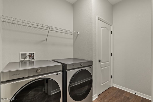 laundry area featuring dark hardwood / wood-style flooring and washing machine and dryer