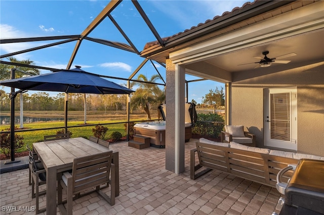 view of patio / terrace featuring a lanai, a hot tub, ceiling fan, and an outdoor living space