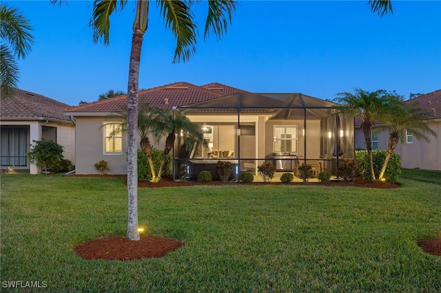 mediterranean / spanish home featuring a lanai and a yard