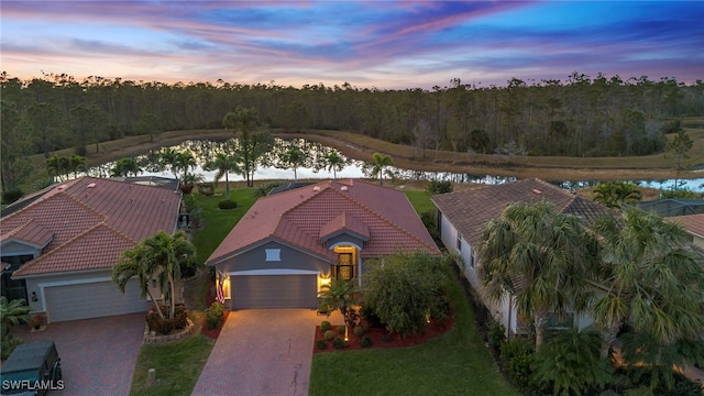 aerial view at dusk featuring a water view