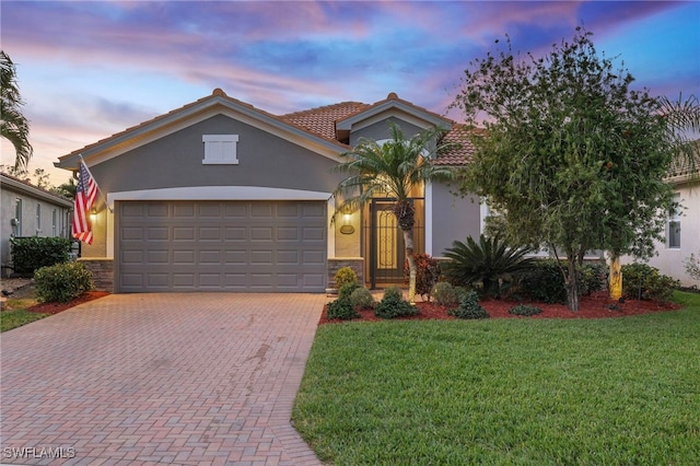 mediterranean / spanish-style house featuring a garage and a lawn