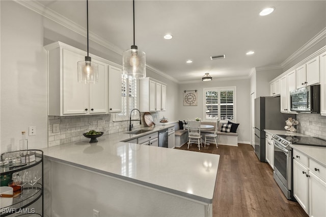 kitchen with stainless steel appliances, sink, white cabinetry, kitchen peninsula, and hanging light fixtures