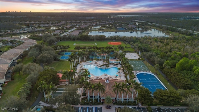 aerial view at dusk featuring a water view