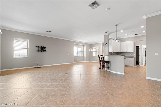 unfurnished living room with a notable chandelier, crown molding, and light tile patterned flooring