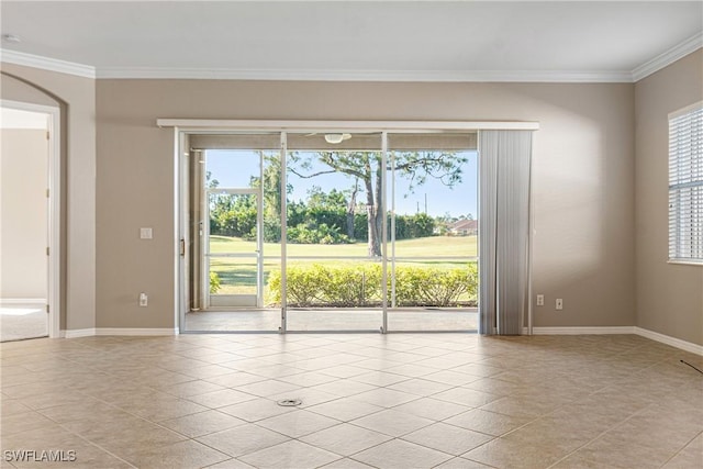 tiled empty room featuring crown molding and a wealth of natural light