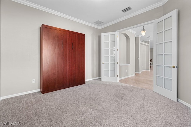 unfurnished bedroom with ornamental molding, light colored carpet, and french doors