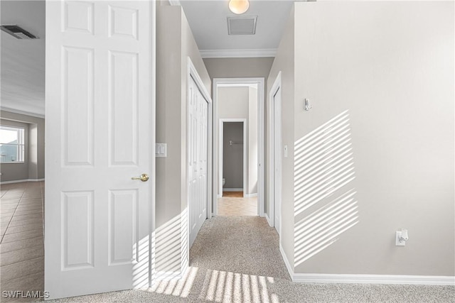 corridor with crown molding and light carpet