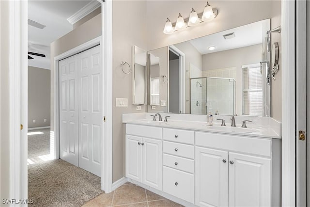 bathroom with a shower with shower door, tile patterned flooring, vanity, ceiling fan, and crown molding