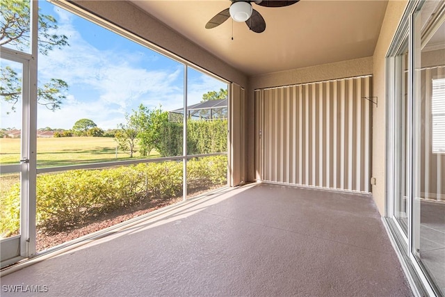 unfurnished sunroom featuring ceiling fan