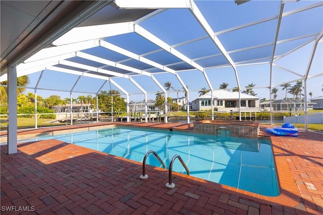 view of swimming pool featuring an in ground hot tub, a patio area, and a lanai