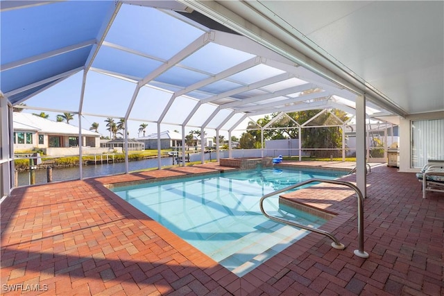 view of pool with a water view, glass enclosure, and a patio area