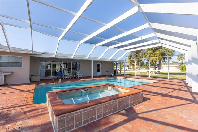 view of swimming pool with glass enclosure, an in ground hot tub, and a patio area