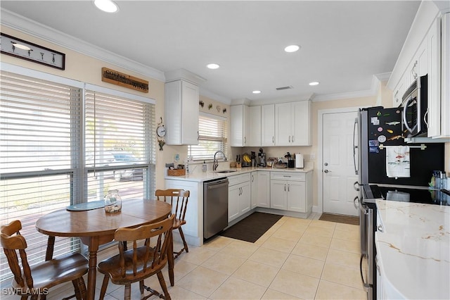 kitchen featuring white cabinetry, sink, light tile patterned floors, and stainless steel appliances