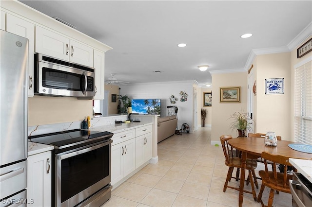 kitchen featuring crown molding, white cabinets, stainless steel appliances, and light tile patterned floors