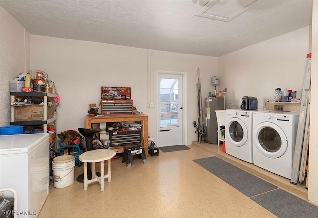 clothes washing area featuring a textured ceiling, separate washer and dryer, and water heater