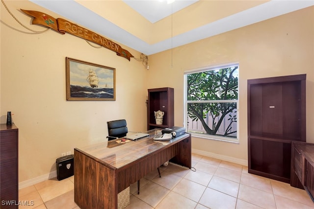 office area featuring a raised ceiling, baseboards, and light tile patterned floors