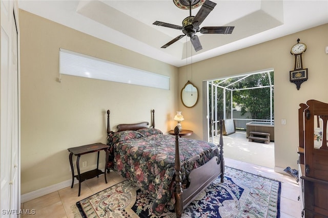 tiled bedroom featuring ceiling fan, baseboards, a raised ceiling, and access to outside