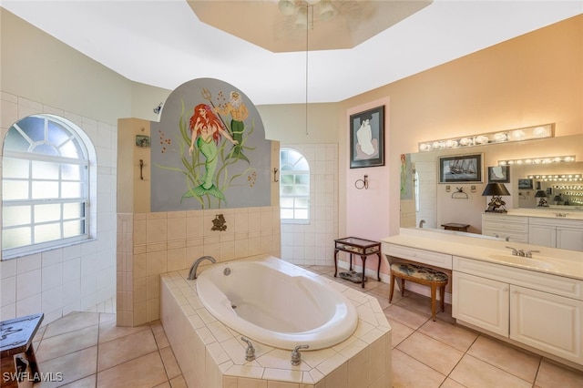 full bath with tile patterned floors, a garden tub, vanity, and a healthy amount of sunlight