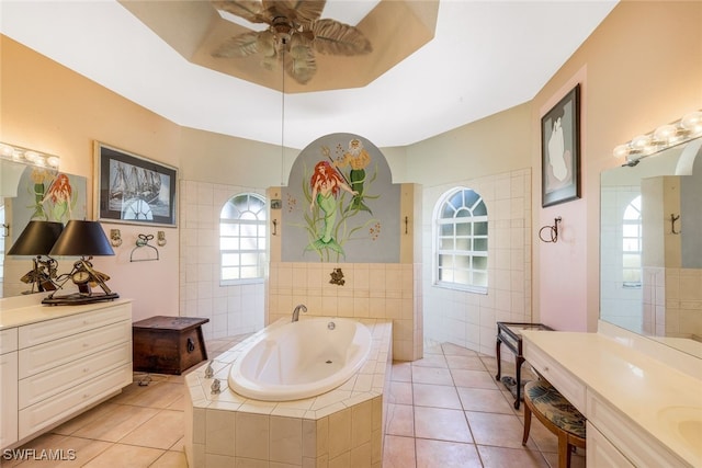 full bathroom featuring tile walls, two vanities, a ceiling fan, tile patterned flooring, and a jetted tub