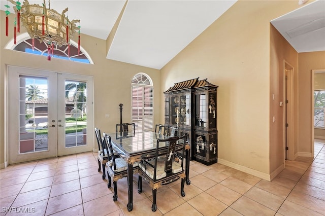 dining space with high vaulted ceiling, french doors, baseboards, and light tile patterned floors