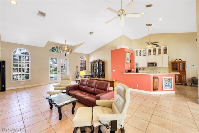 living room featuring light tile patterned floors, high vaulted ceiling, ceiling fan with notable chandelier, and visible vents