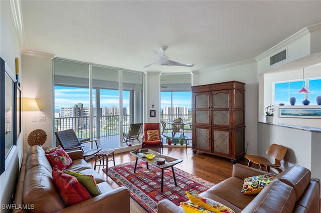 living room with expansive windows, hardwood / wood-style flooring, ceiling fan, and ornamental molding